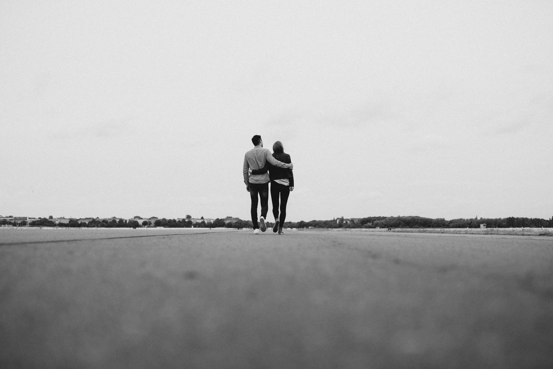 couple walking away black and white