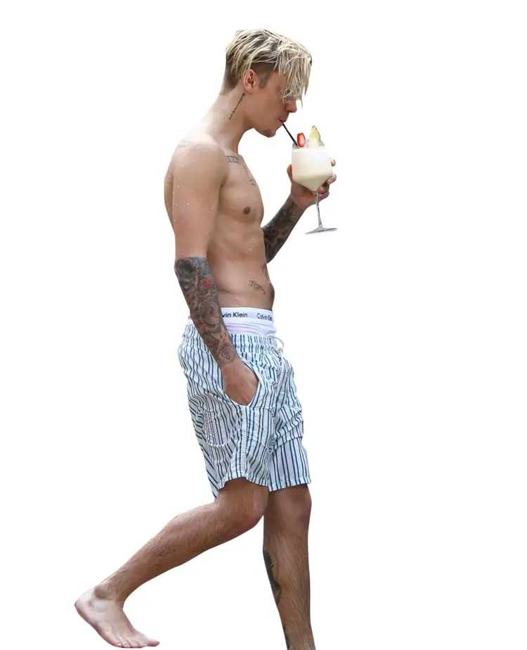 Shirtless Man with Tattoos Walking with a Drink