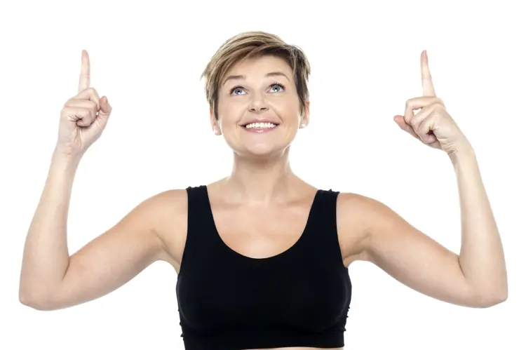Smiling Woman in Casual Attire Pointing Up