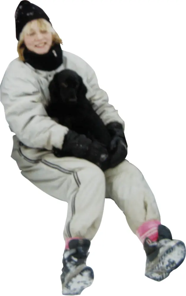 Woman in Winter Clothing Holding a Dog