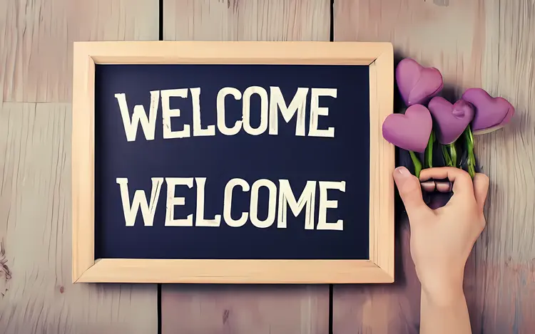 Welcome Sign on Chalkboard with Hand